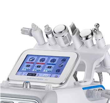 Prim-plan cu ecranul tactil pornit al combinei cosmetice Hydrafacial, evidentiind meniul digital de selectare a functiilor si capetele de lucru in spate.