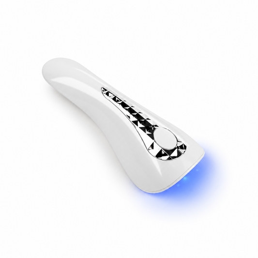 Mini lampă UV LED 18W portabilă cu acumulator, albă cu detalii argintii, cu lumina albastră aprinsă.