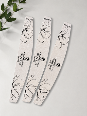 Pilă profesională pentru unghii Cosmeticos x Staleks, formă semilună, granulație 180/180, ideală pentru pilirea și finisarea unghiilor naturale și tehnice, pe fundal floral.