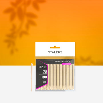 Set de 100 de bețișoare din lemn de portocal pentru manichiură STALEKS EXPERT DOS-20/100, 75 mm, în ambalaj original pe fundal portocaliu.
