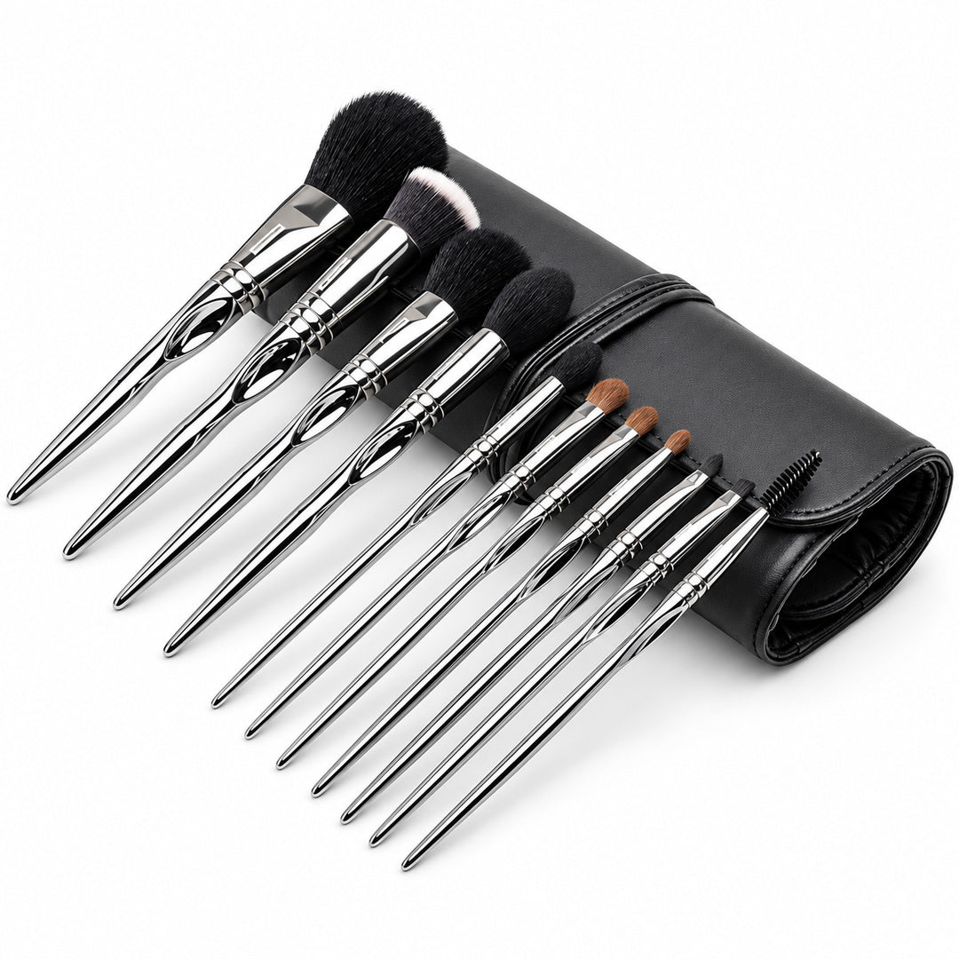 Set 11 pensule profesionale de machiaj Silver Touch, cu mânere argintii, așezate oblic lângă accesoriul negru rulat.