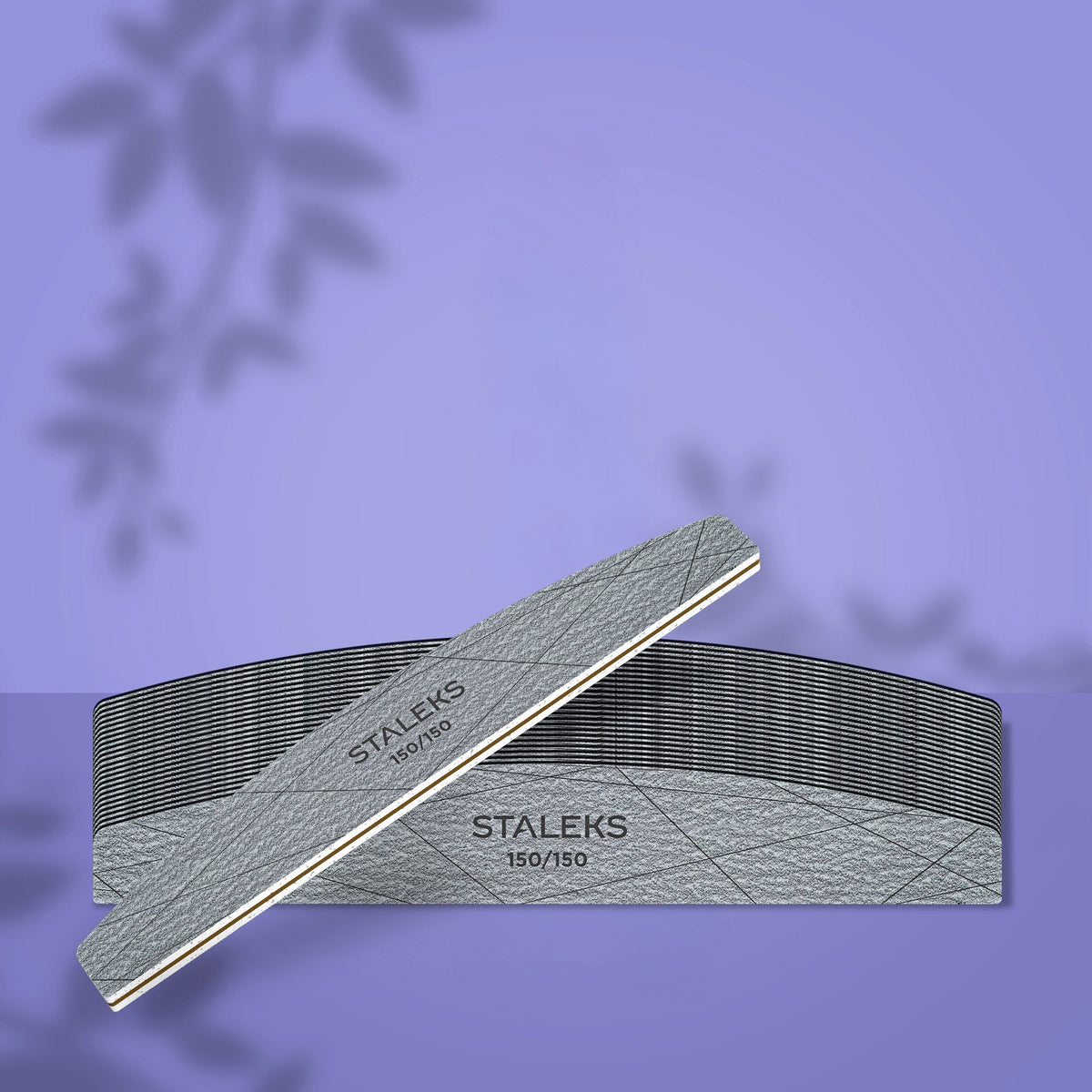 Set de 25 de pile semilună STALEKS SMART 40, cu granulație 150/150 pentru unghii artificiale, prezentat pe fundal mov cu o pilă așezată oblic în prim-plan.