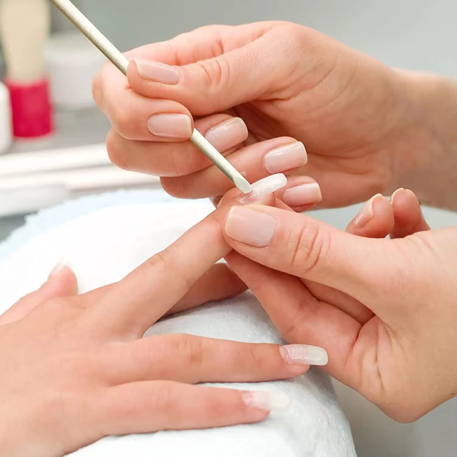 Demonstratie practica in salon unde tehnicianul utilizeaza capatul tesit al unui betisor de portocal pentru stilizarea si curatarea zonei cuticulei.