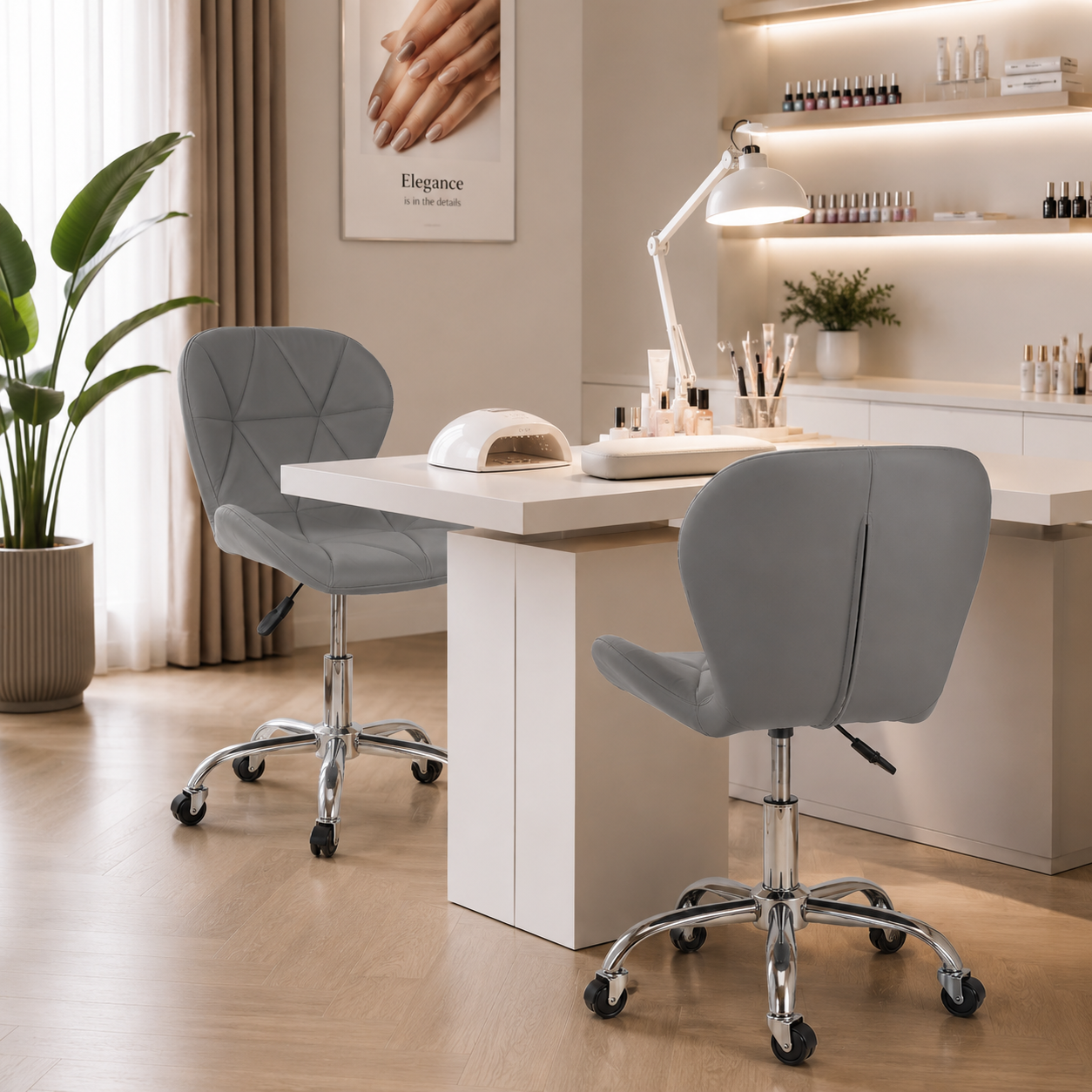 Doua scaune cosmetice gri asezate langa o masa alba de manichiura dotata cu o lampa de unghii, intr-un salon luminos.